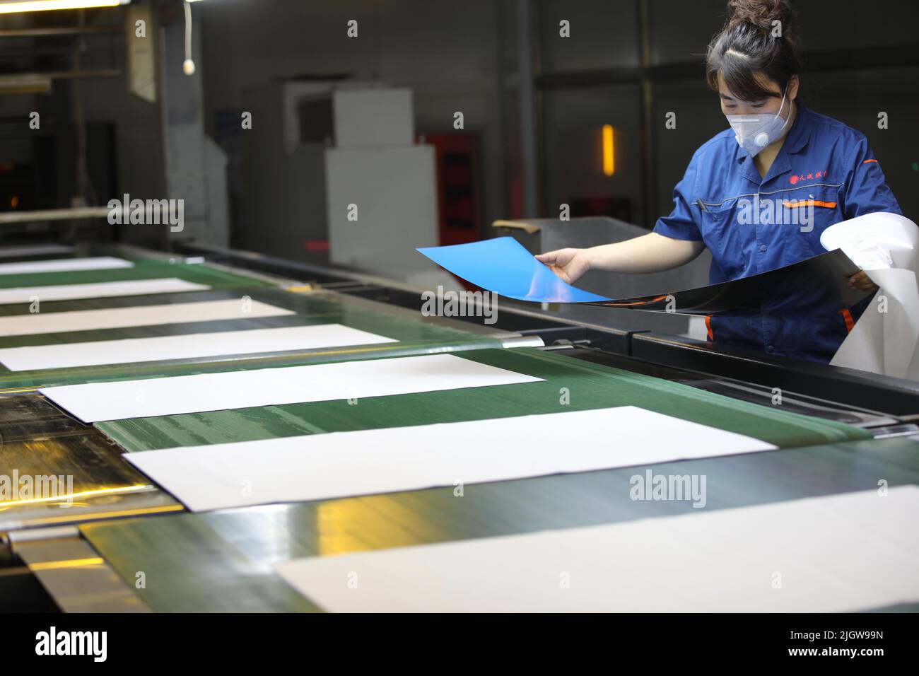 CHENGDE, CINA - 11 LUGLIO 2022 - Un lavoratore controlla la qualità del rivestimento fotosensibile su lastra di stampa in una fabbrica di lavorazione di lastre di stampa a che Foto Stock