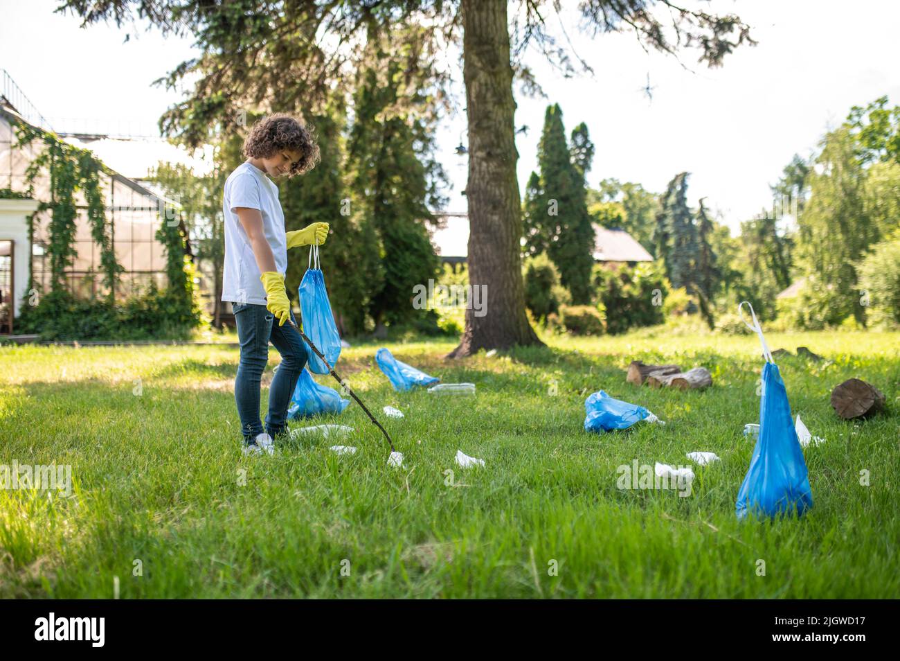 Carino giovane volontario pulizia del parco da rifiuti di plastica Foto Stock