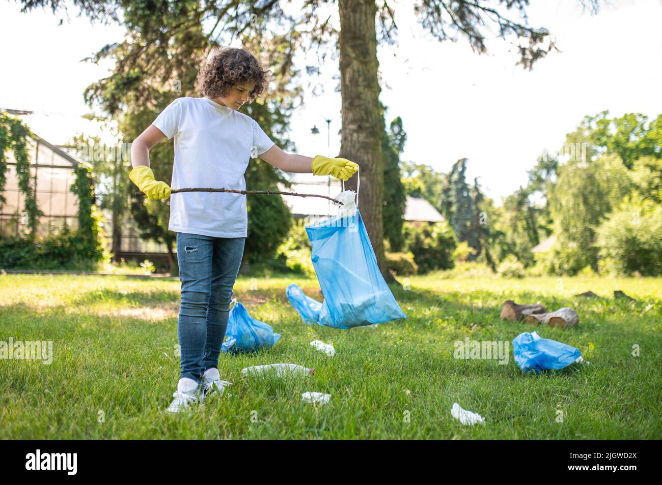 Carino giovane volontario pulizia del parco da rifiuti di plastica Foto Stock