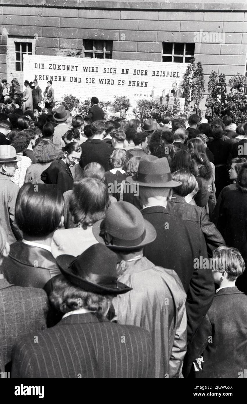 Menschenmenge auf einer Kundgebung zum Tag des freien Buches vor der Humboldt-Universität in Berlin, Deutschland 1947 - Zitat: Romain Rolland: Die Zukunft wird sich an euer Beispiel erinnern und sie wird es ehren Foto Stock
