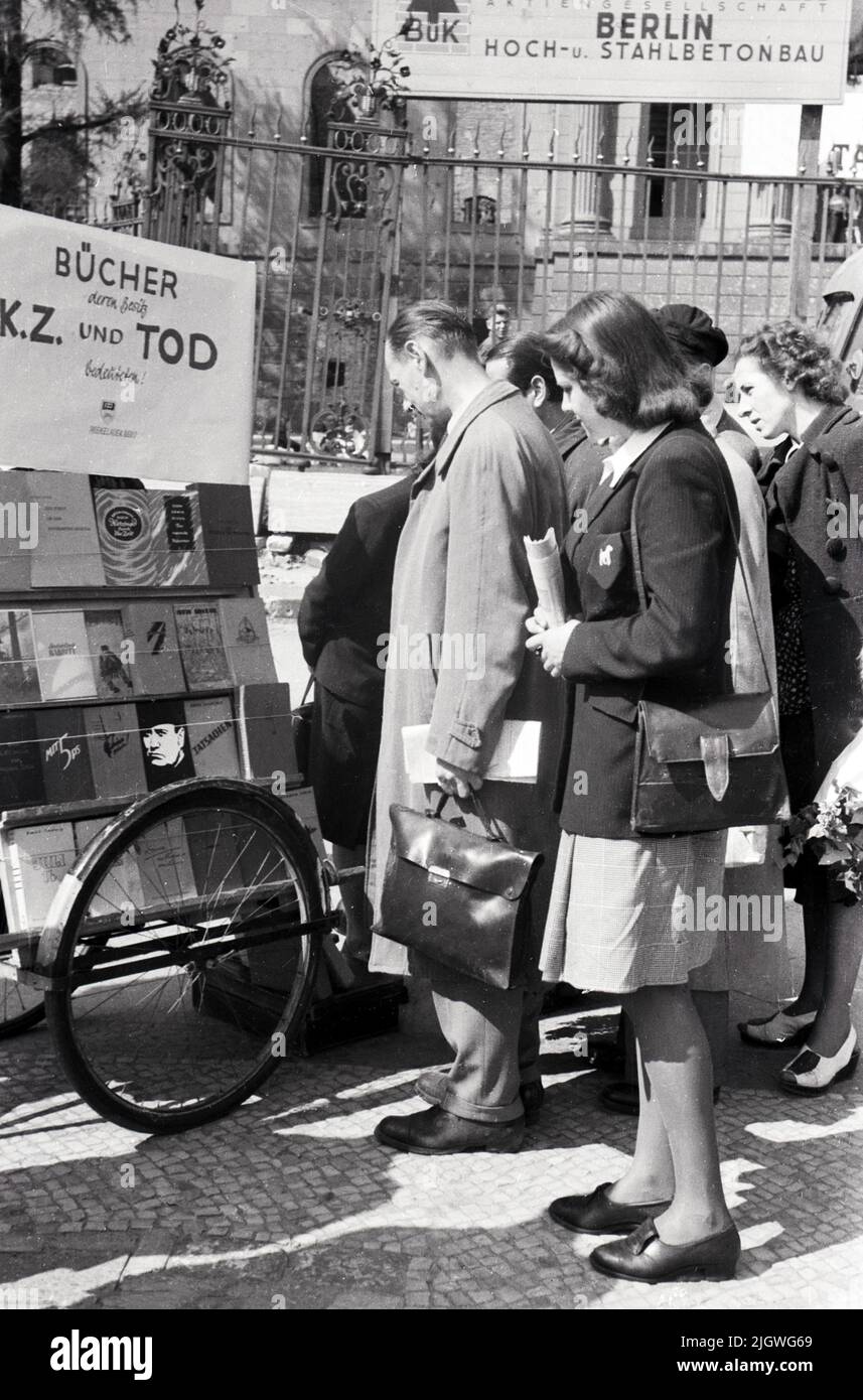 Passanten sehen sich im Dritten Reich verbotene Literatur während einer Kundgebung zum Tag des freien Buches vor der Humboldt-Universität a Berlino An, Deutschland 1947. Foto Stock