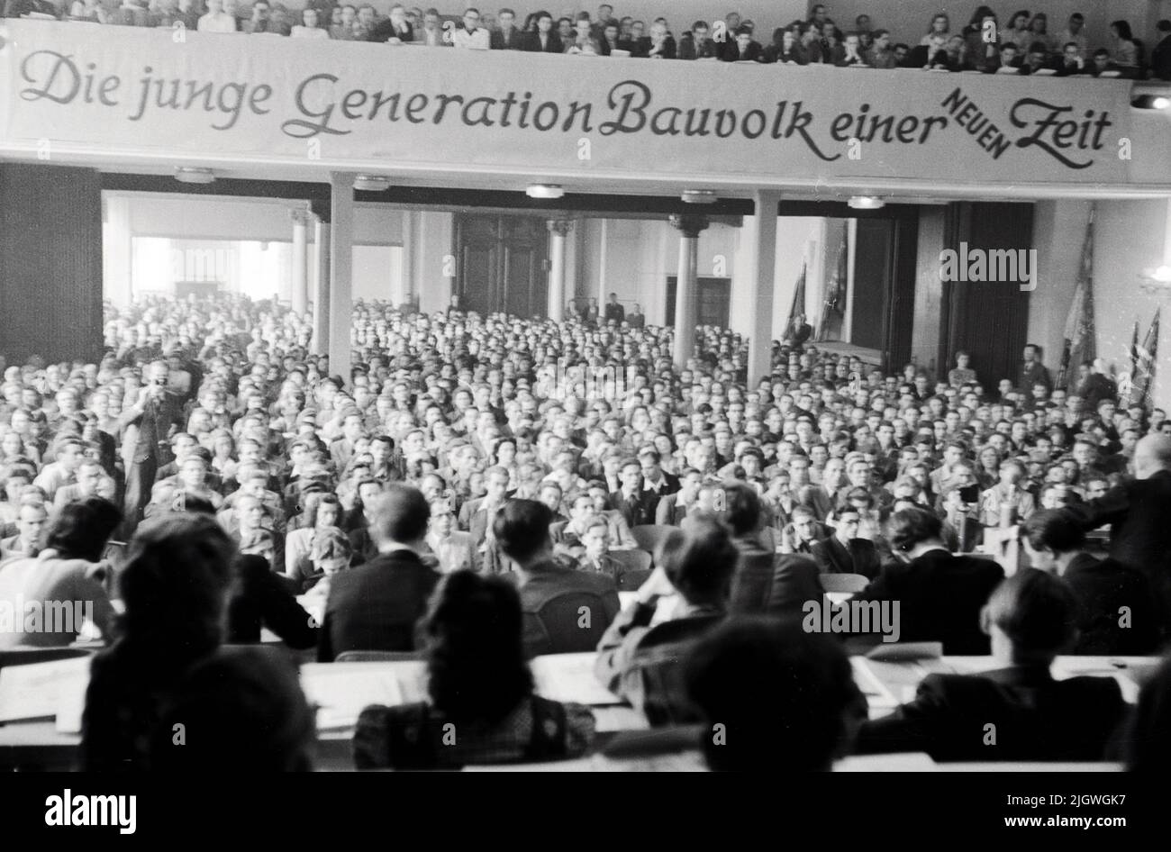 Blick ins Publikum und auf das Banner 'Die junge Generation Bauvolk einer neuen Zeit' beim Pfingsttreffen und 2. Parlament der FDJ a Meissen, Deutschland 1947. Foto Stock