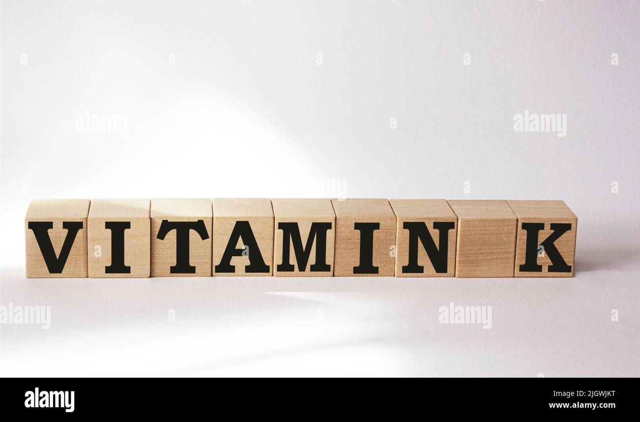 VITAMINA K. il testo è a cubetti e su sfondo bianco. Soluzione brillante per la medicina, concetto di marketing Foto Stock