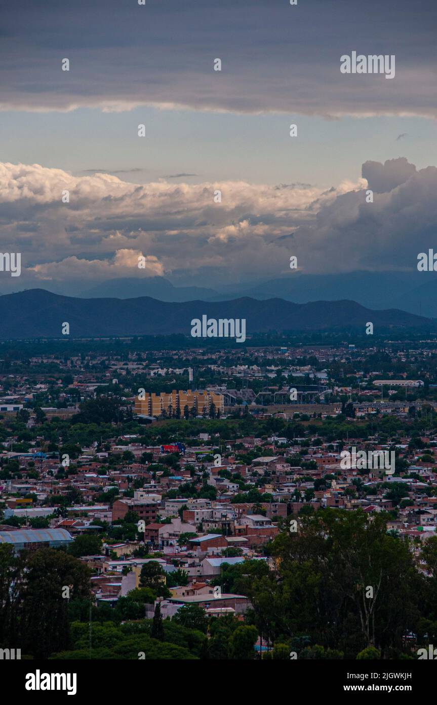 Una vista aerea verticale del paesaggio urbano di Salta, Argentina contro le montagne al tramonto Foto Stock