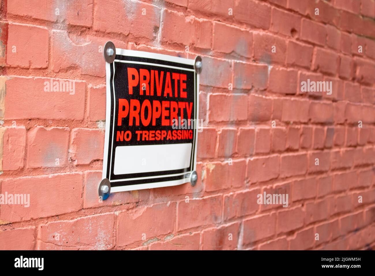 proprietà privata senza segno di tregua su un muro di mattoni in prospettiva angolo Foto Stock