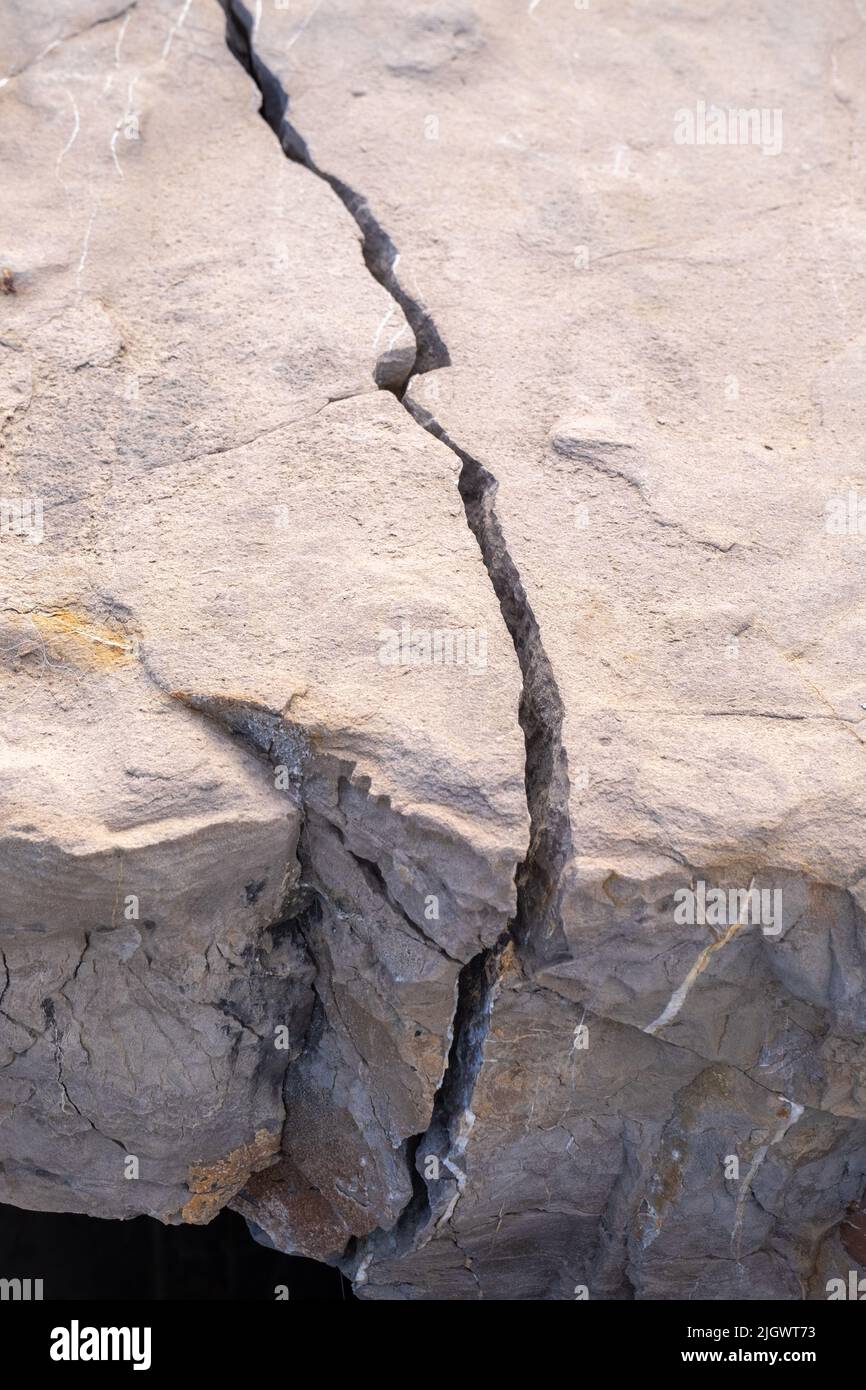 Primo piano di una roccia rotta in due parti dalle maree del mare su una spiaggia sulla costa di Malaga in Spagna. Foto Stock