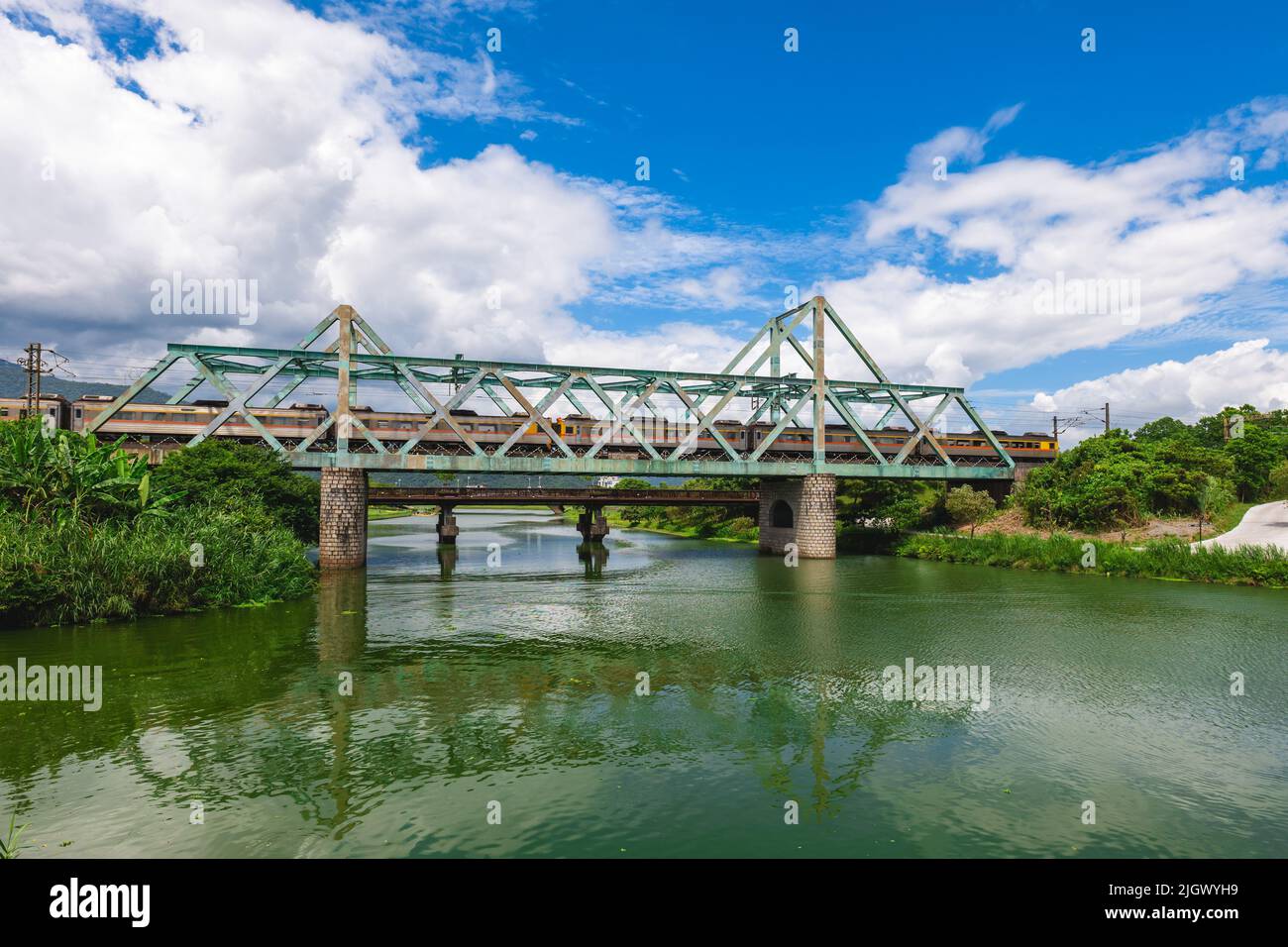 Treno passa il ponte di ferro al parco ecologico del fiume Dongshan a yilan, taiwan Foto Stock
