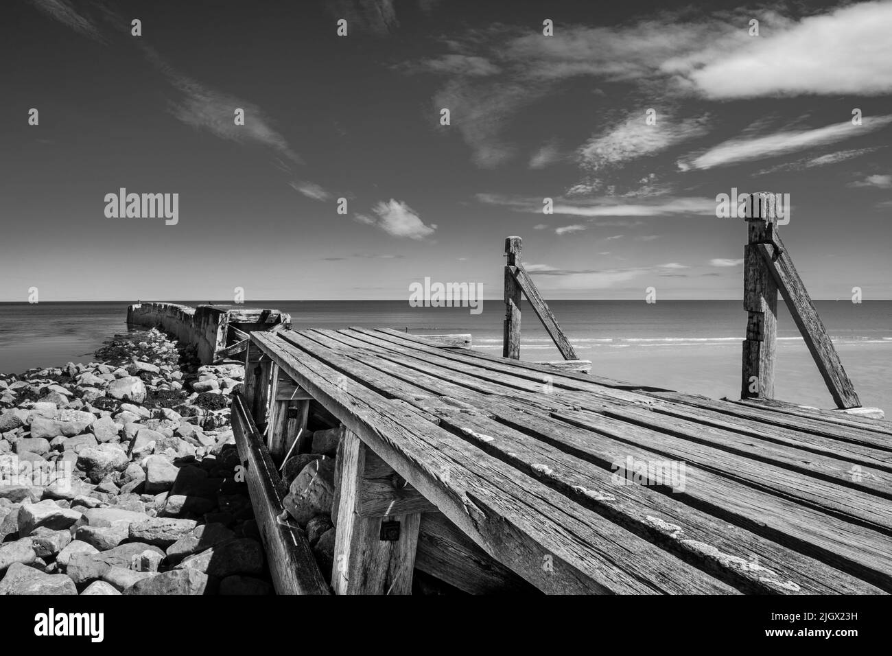 Vecchio frangiflutti alla spiaggia di Lossiemouth in Black and White, Moray Coast Scotland Foto Stock