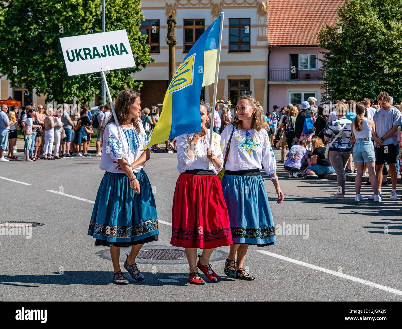 Straznice, Repubblica Ceca - 25 giugno 2022 Festival Internazionale del Folklore tre ragazze ucraine con una bandiera in costumi folcloristici Foto Stock