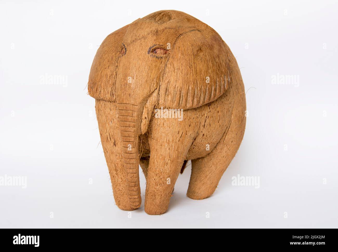 Una figurina ricordo di un elefante fatto di cocco su un isolato sfondo bianco. Foto Stock