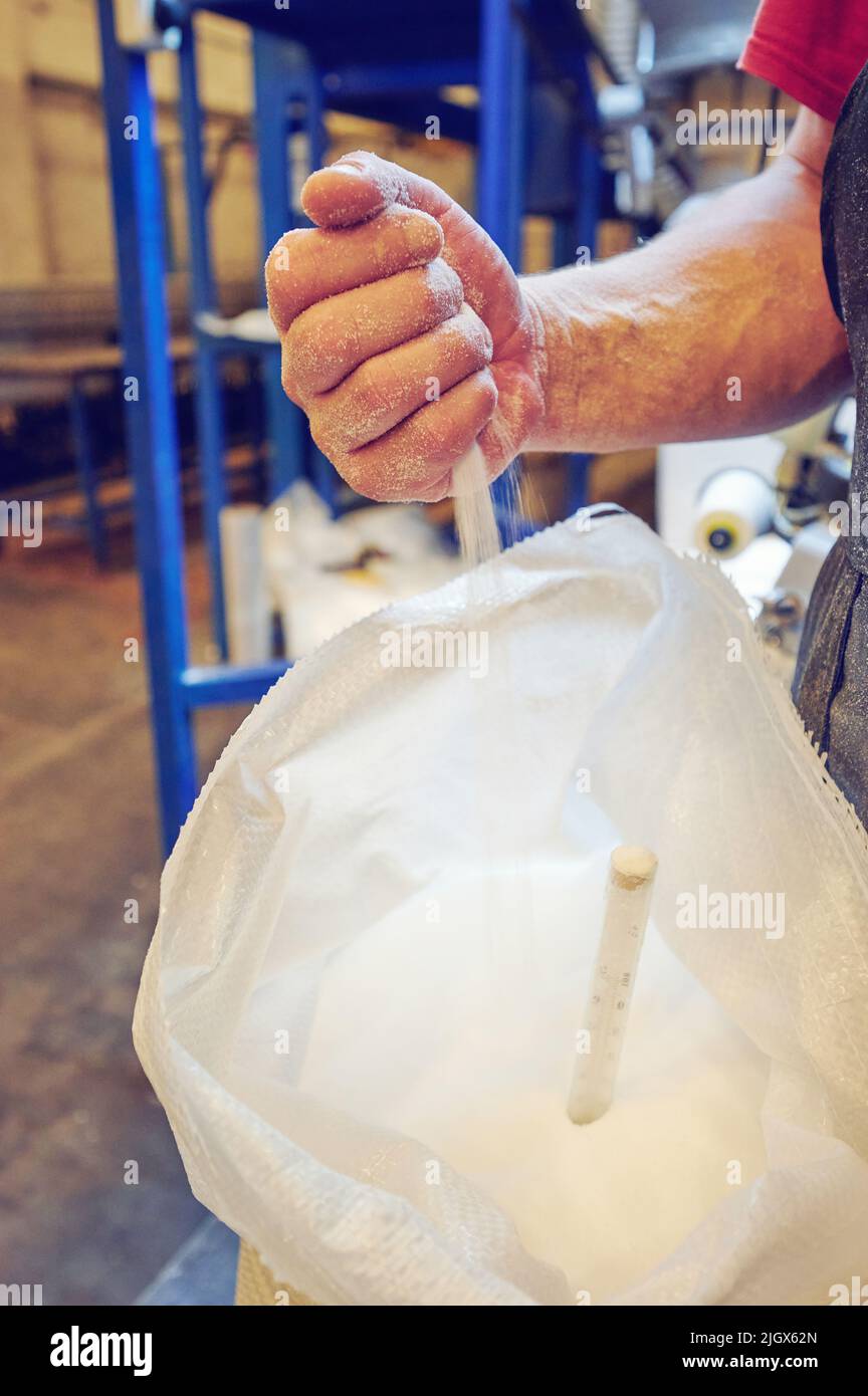 Controllare il composto granulare bianco nel locale industriale di smistamento Foto Stock
