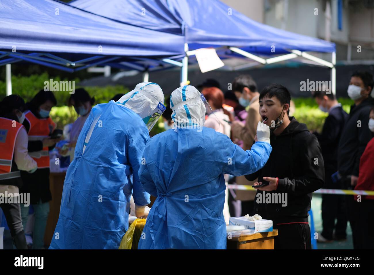 Shanghai, Cina-Marzo 24th 2022: Heath lavoratore che raccoglie campioni di tampone da residenti per test di acido nucleico nel distretto residenziale. Shanghai è in su Foto Stock