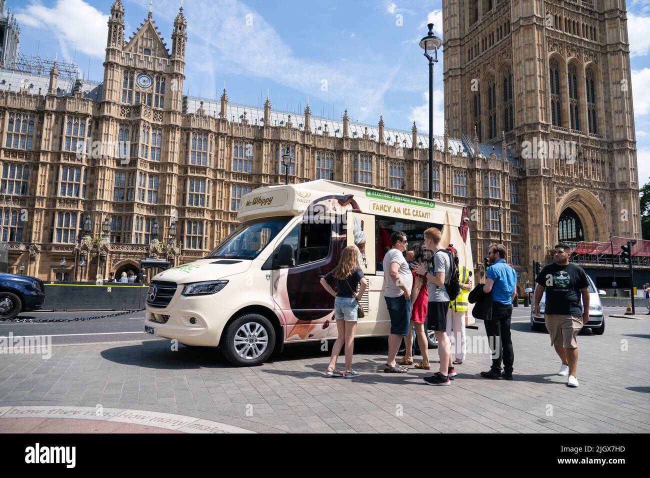 La gente si accaparrerà per un furgone elettrico per gelato fuori dal Parlamento, a Westminster, Londra, mentre il recente periodo caldo continua, con la possibilità di temperature record all'inizio della prossima settimana. Foto Stock