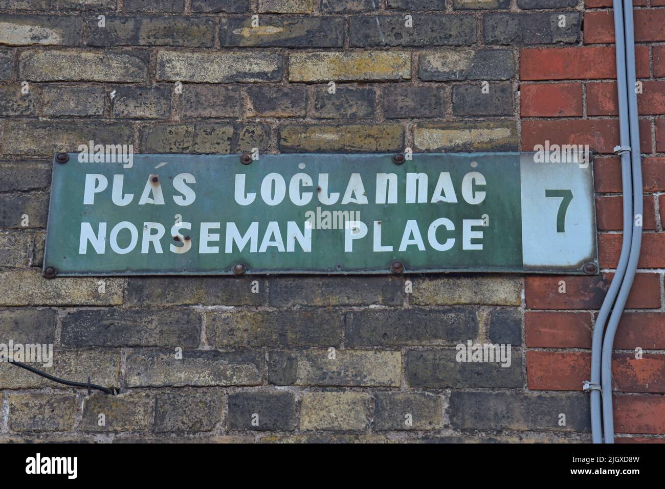Un cartello stradale bilingue vintage per Norseman Place nella zona alla moda della città interna di Stoneybatter, Dublino, Irlanda, luglio 2022 Foto Stock