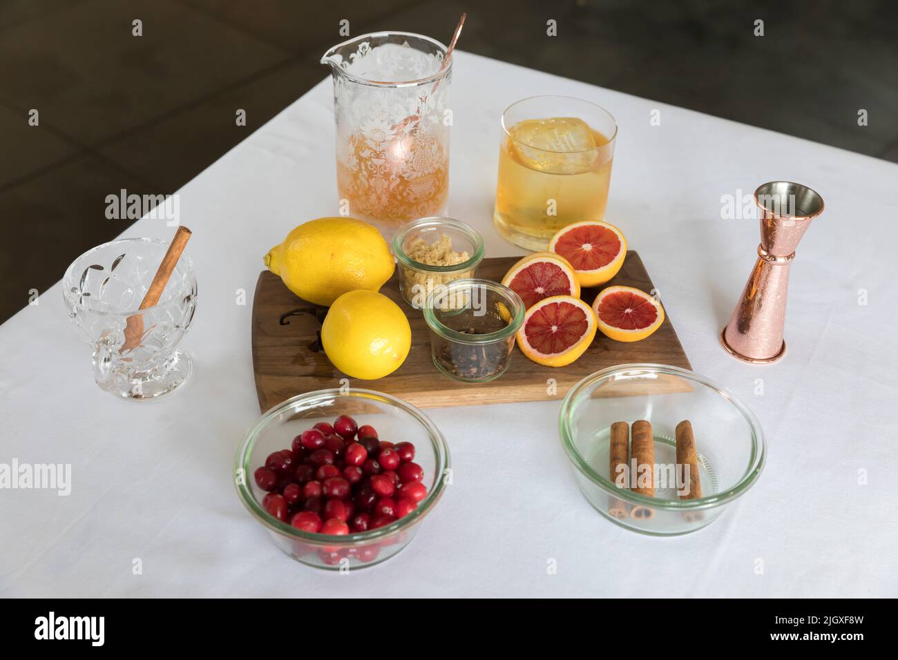 Ingredienti per cocktail autunnali su un panno da tavolo bianco Foto Stock