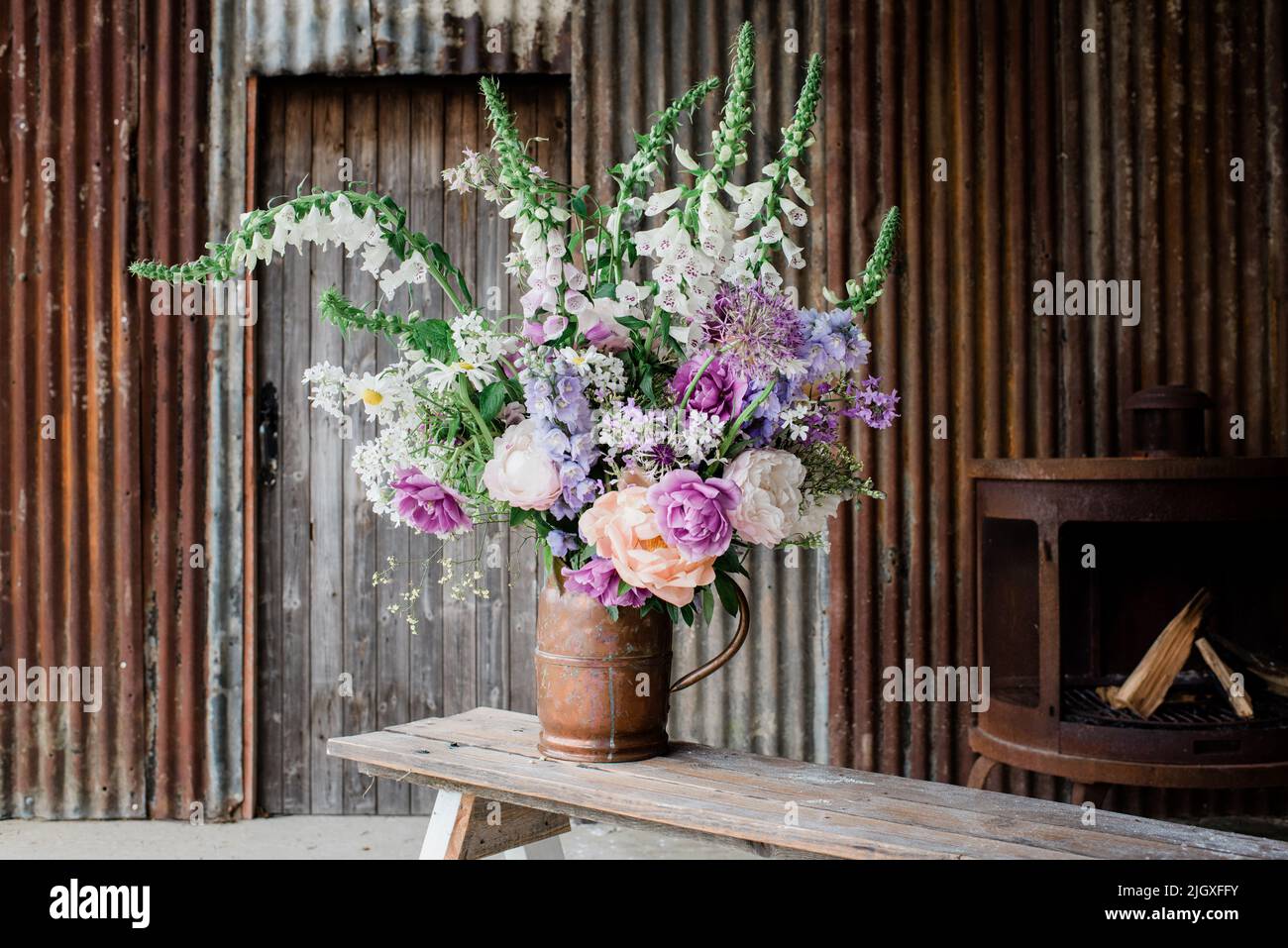 bei fiori impostati da un fiorista per un photoshoot in un vecchio fienile Foto Stock