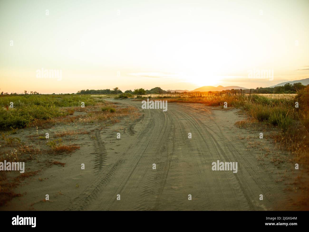 Strada di campagna e la vista con un tramonto e naselli sotto Foto Stock
