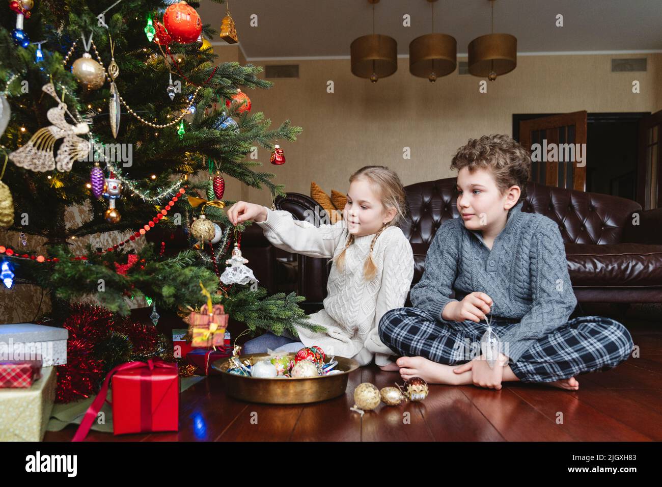 I bambini decorano l'albero di Natale con i giocattoli di Natale. Foto Stock