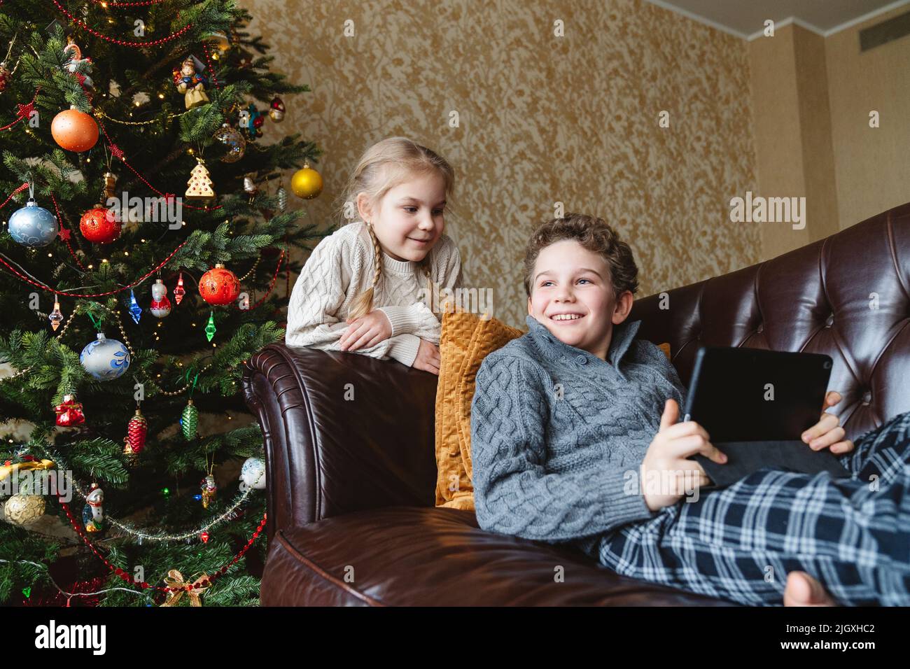 I bambini si divertono vicino all'albero di Natale. Foto Stock