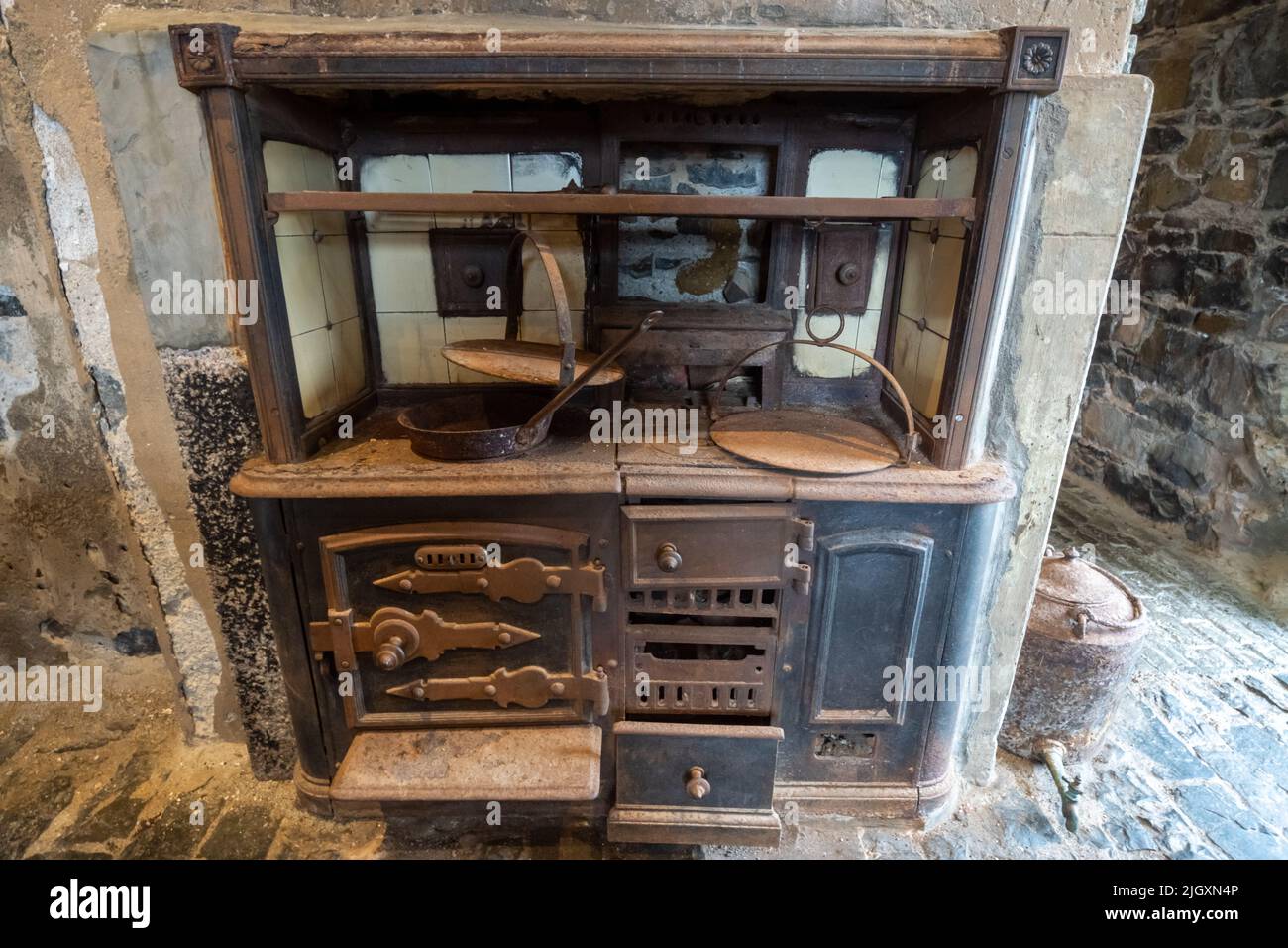 Cucina vecchia in arrugginita Aga o Range con pentole in metallo, Scozia, Regno Unito Foto Stock