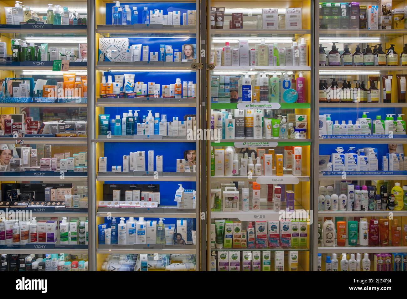 Mariupol, Ucraina - 15 luglio 2021: Scaffali di farmacia pieni di diversi prodotti cosmetici medici primo piano. Medicinali sistemati in ripiani per finestre. Medico Foto Stock