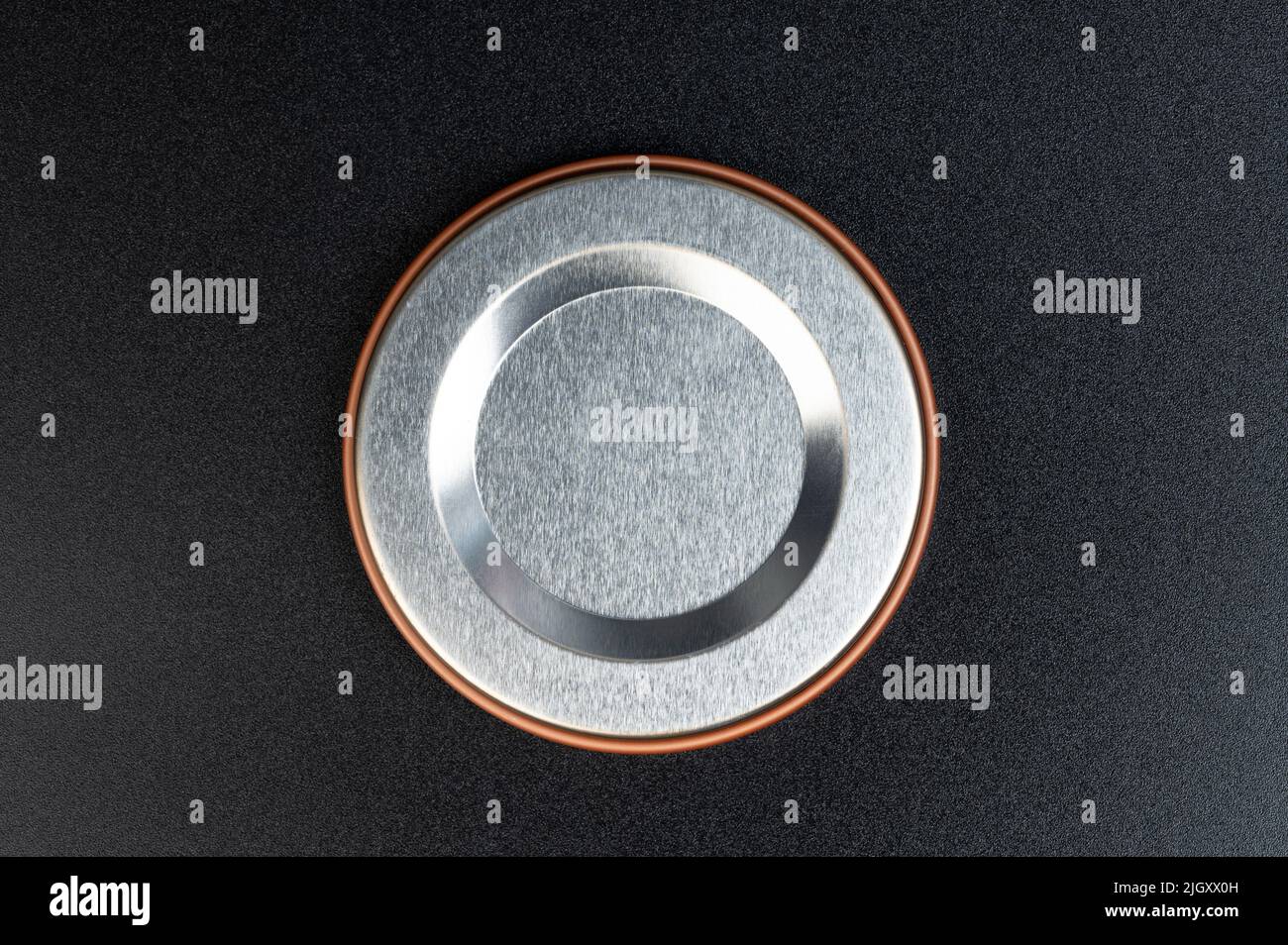 Cerchio lucido in metallo su sfondo nero opaco, vista ravvicinata Foto Stock