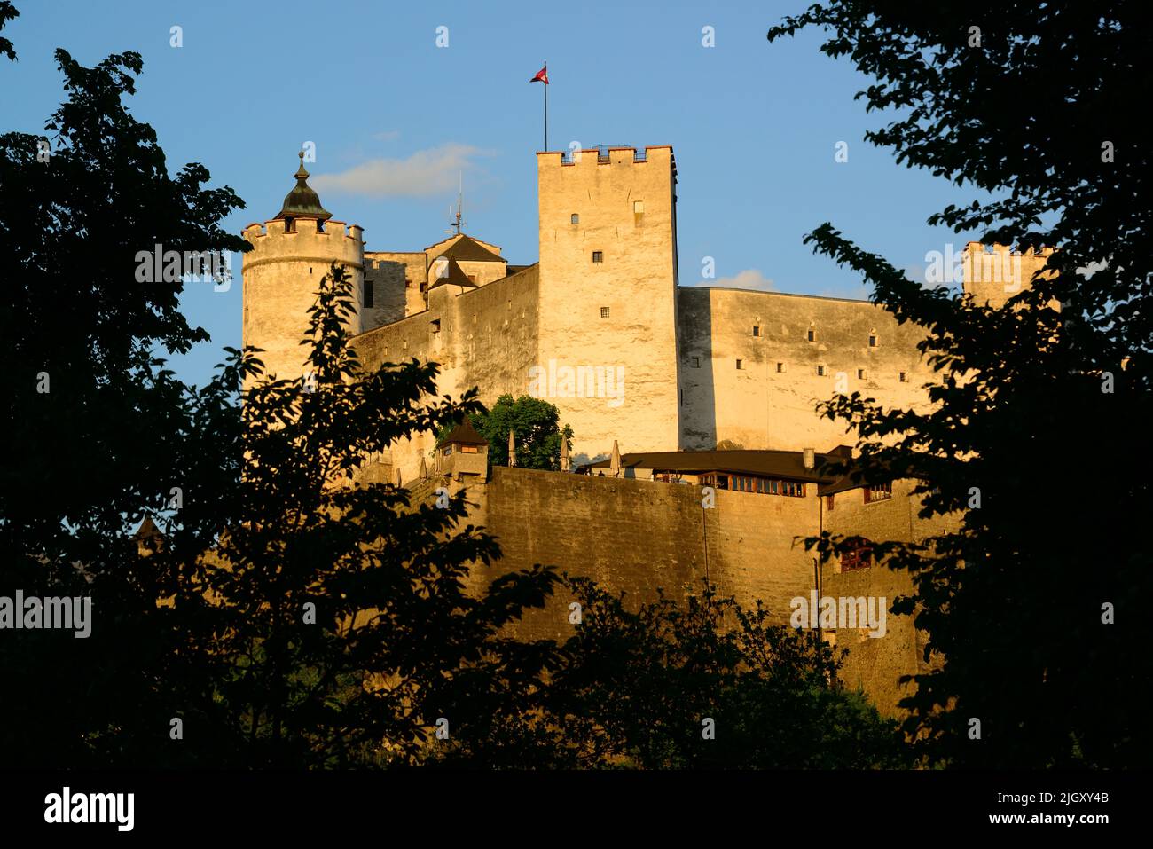 Una vista illuminata dal sole della splendida fortezza medievale di Hohensalzburg nella panoramica città austriaca di Salisburgo Foto Stock