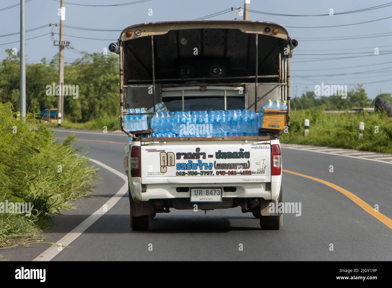 THAILANDIA, 11 2022 GIUGNO, Un'auto carica di bottiglie di acqua potabile sta guidando sulla strada rurale Foto Stock