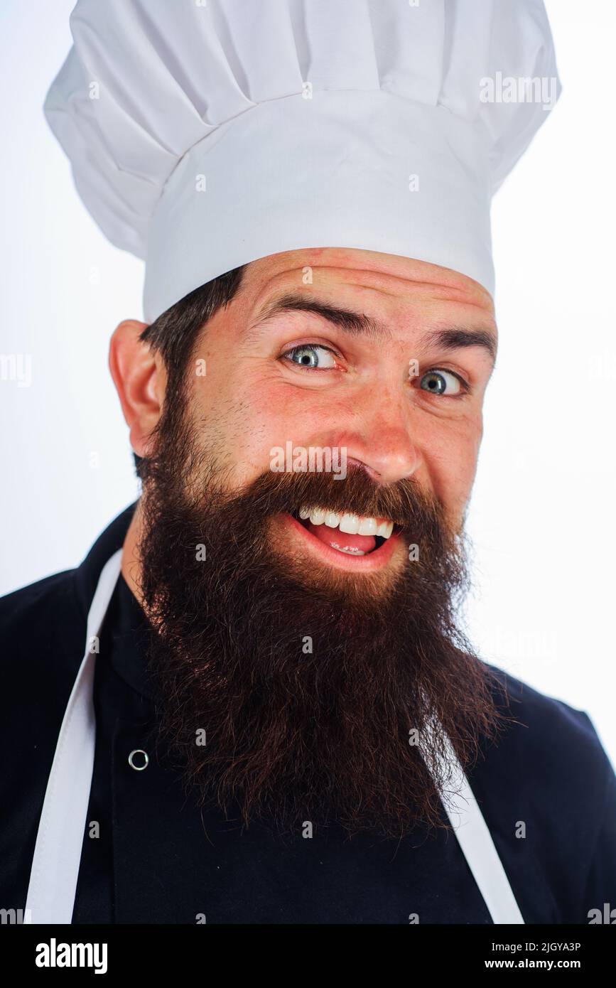 Uomo barbuto in uniforme. Cuoco maschile o panettiere in cappello bianco e grembiule. Ritratto di chef sorridente. Cucina. Foto Stock