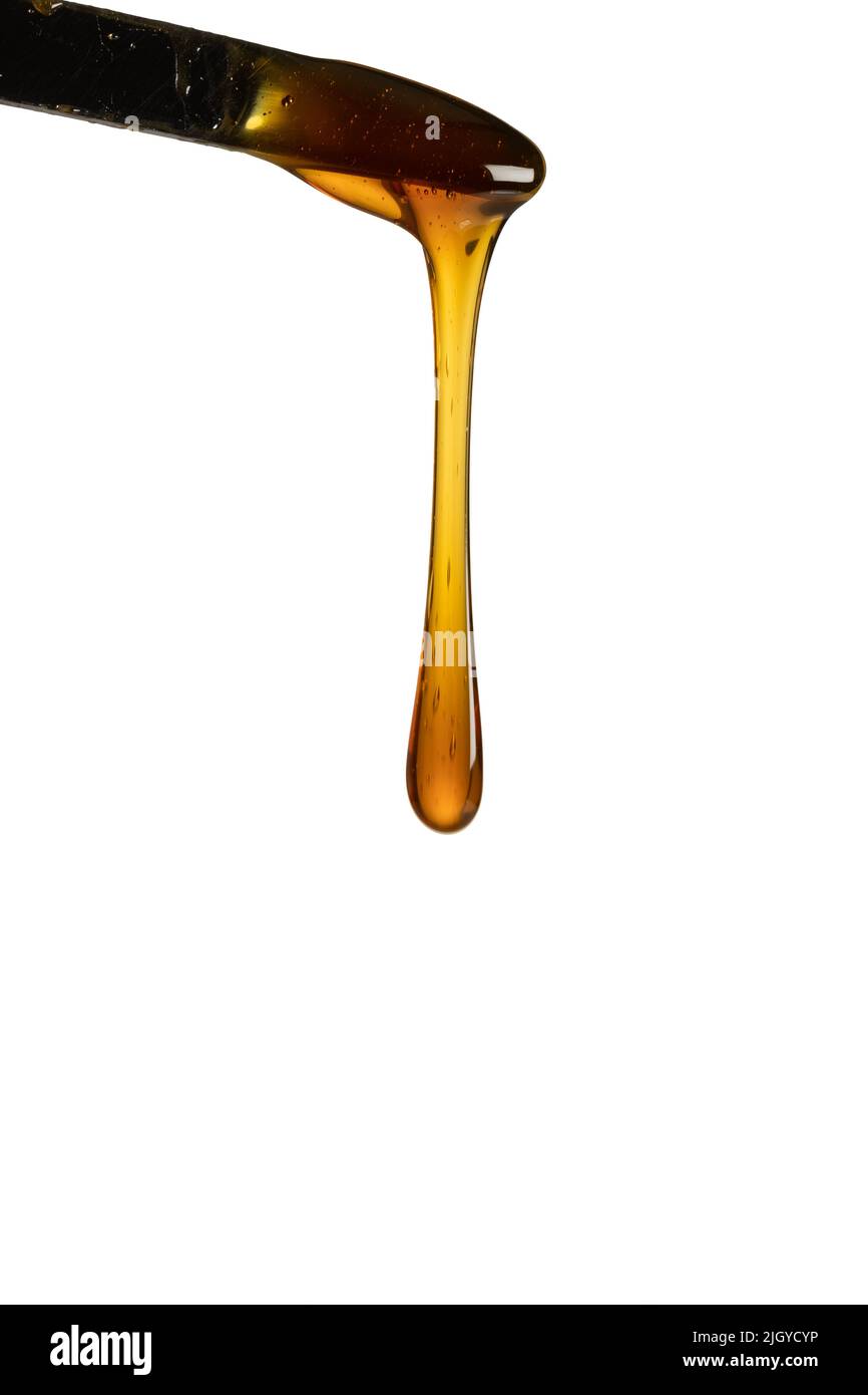 Miele gocciolante isolato su sfondo bianco Foto Stock