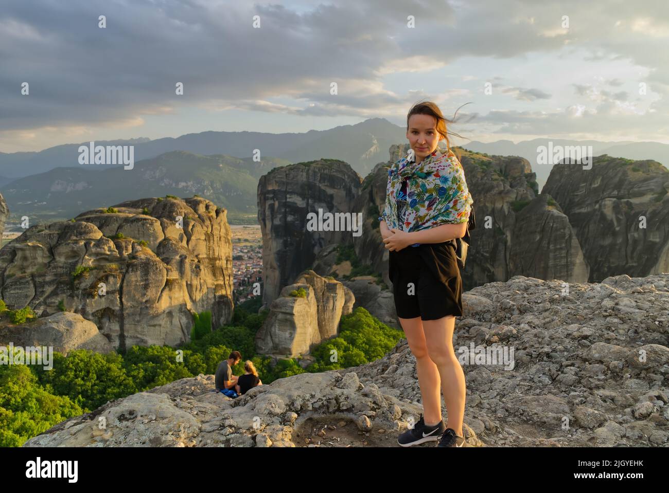 Giovane ragazza turistica sulla cima della montagna al tramonto. Grecia, Meteora Foto Stock