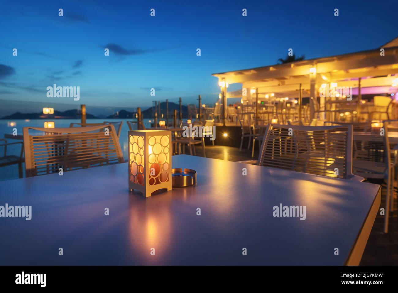Bella lampada sul tavolo in caffè sulla costa del mare di notte Foto Stock
