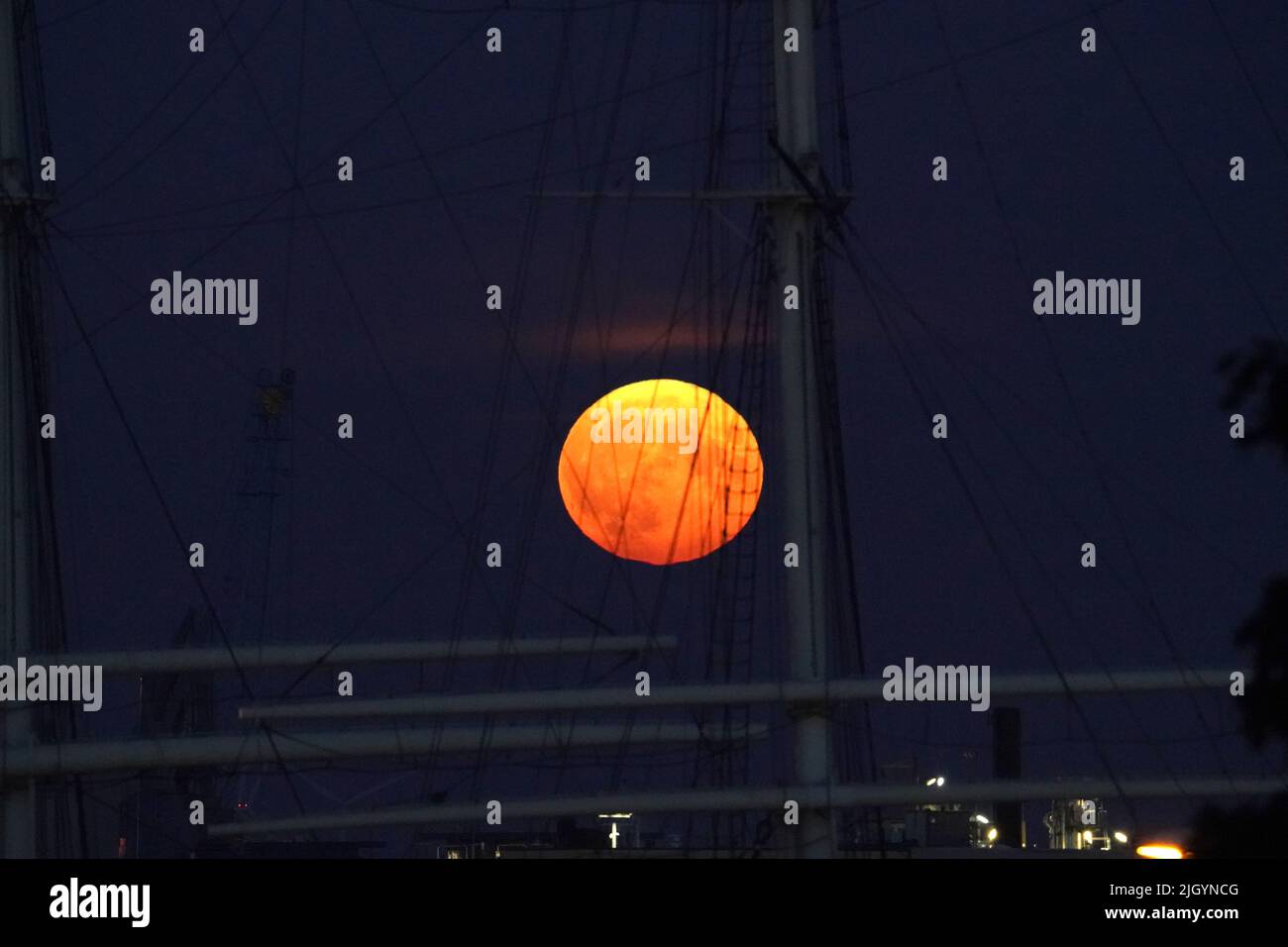 Amburgo, Germania. 13th luglio 2022. La luna piena sorge sul porto di Amburgo in serata. Allo stesso tempo, la luna è vicina alla terra, ed è per questo che è chiamata una superluna. Credit: Marcus Brandt/dpa/Alamy Live News Foto Stock