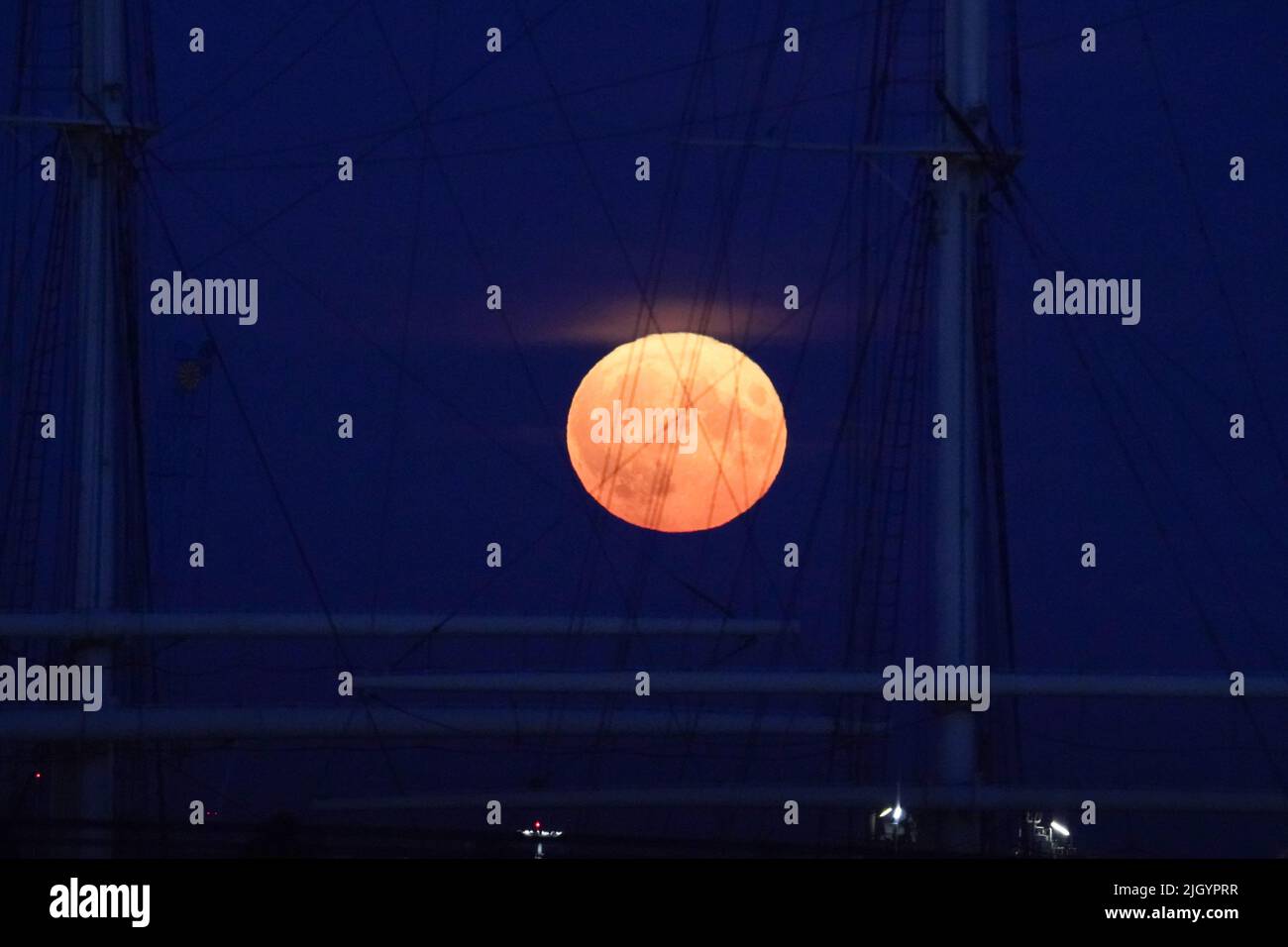 Amburgo, Germania. 13th luglio 2022. La luna piena sorge sul porto di Amburgo in serata. Allo stesso tempo, la luna è vicina alla terra, ed è per questo che è chiamata una superluna. Credit: Marcus Brandt/dpa/Alamy Live News Foto Stock
