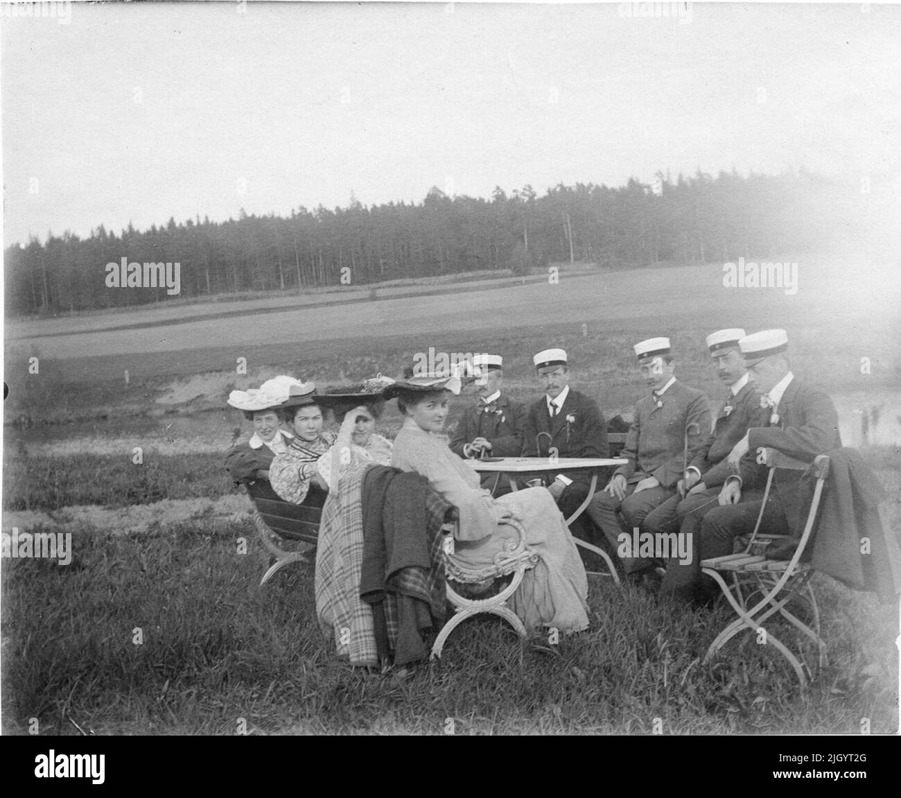 Studenti, donne e uomini seduti a tavola su erba, foresta sullo sfondo, probabilmente Uppland intorno al 1900. La foto scattata intorno al 1900. La foto fa parte di una raccolta di foto donate da Kerstin Hallström, Uppsala, 8 novembre 1976. Queste immagini sono legate al tempo studentesco di Padre Harald Falk (1895-1905) a Uppsala. Harald Falk visse nella casa studentesca di Norrbyska a Uppsala, appartenne alla nazione Västmanland-Dala, e divenne poi sacerdote a Åtvidaberg, Östergötland e Stora Tuna, Dalarna. Nel 1919 morì nella malattia spagnola. 1895 - 1905 evento storico, nome relativo a Objek: Falk, Foto Stock