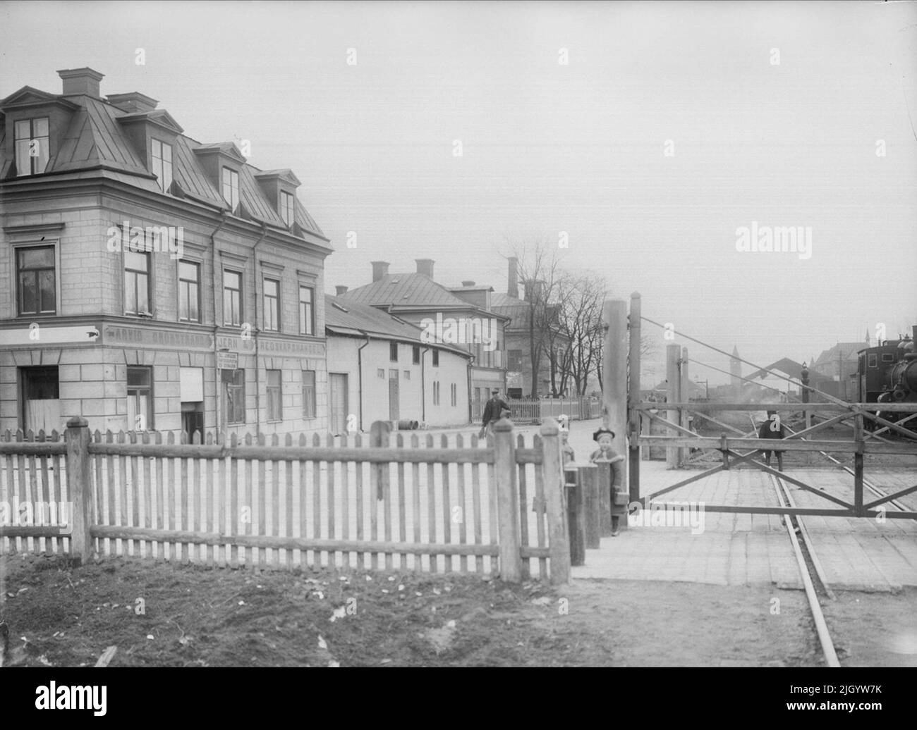 Il passaggio ferroviario a Vaksalagatan, Uppsala 1901 - 1902. Il passaggio ferroviario a Vaksalagatan. La ferrovia Stoccolma-Uppsala è stata completata nel 1866. Fin dall'inizio, il cantiere è arrivato all'interno di parti costruite e programmate città della città, che ha causato a lungo problemi di traffico, soprattutto all'incrocio ferroviario di Vaksalagatan. La zona ferroviaria fu recintata con la recinzione e alle transizioni vi erano cancelli di legno, che furono ancora aperti e chiusi manualmente alla fine del secolo. A sinistra quartiere Siv. 'Da Ola EHN & Gunnar Elfström, la fine del secolo Uppsa Foto Stock