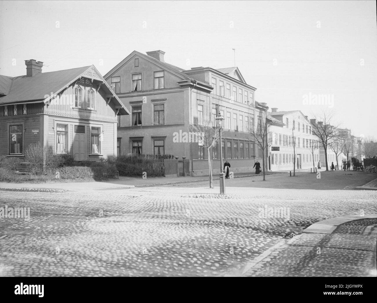 L'angolo di Syslomansgatan - Skolgatan, quartiere Hervor, Luthagen, Uppsala 1901 - 1902. L'angolo di Syslomansgatan - Skolgatan. All'angolo tra Syslomansgatan e Skolgatan, sulla ancora inesplorata Luthagen, fu eretta una casa singola -familiare nel 1868 che può essere considerata la prima villa di Uppsala. La villa ricevette un abbondante ornamento con un'opera tipica del tempo. A pochi anni dal 20th secolo fu demolita e sostituita dalla cosiddetta casa Rappska, una delle più magnifiche liberty di Uppsala. L'architetto di città C A Ekholm ha eseguito i disegni per conto di Th Foto Stock