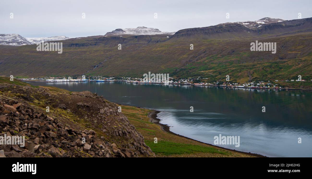 Vista sul fiordo di Eskifjörður, un piccolo braccio laterale del fiordo di Reyðarfjörður verso la piccola città di Eskifjörður, un porto dell'Islanda orientale con un lar Foto Stock