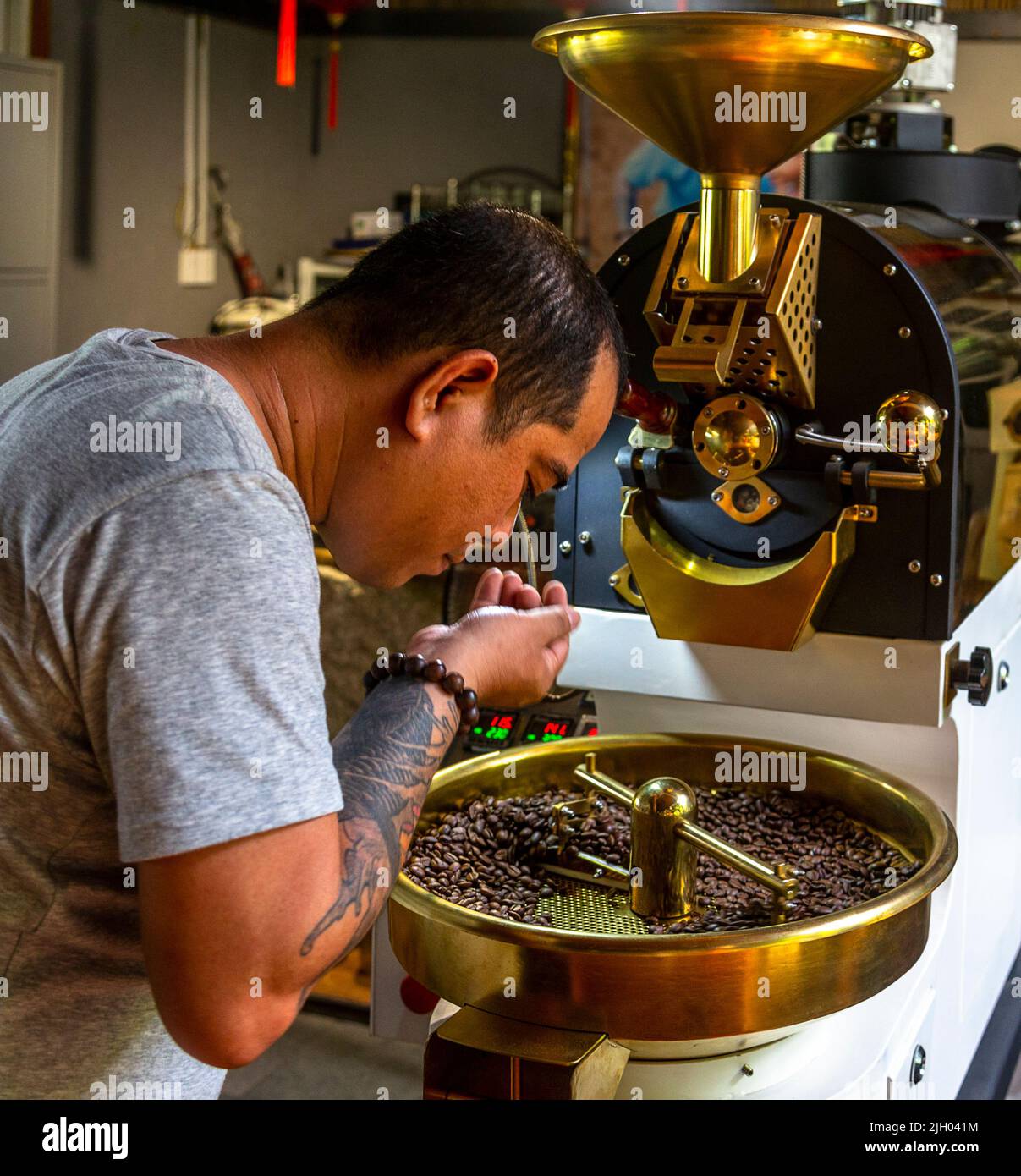 Il Sig. Thanh controlla i chicchi di caffè prima di passare alla fase successiva. Foto Stock