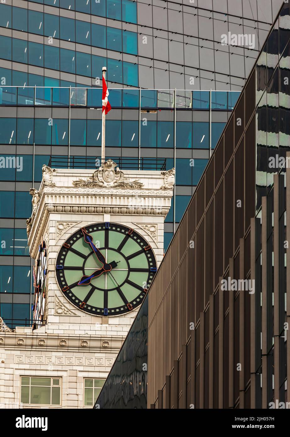 La torre dell'orologio Mission Impossible con bandiera canadese ondeggiante è vista in cima al Vancouver Block Building bianco su Granville Street nel centro di Vancouver Foto Stock