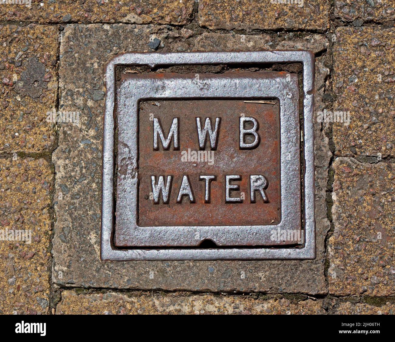 Griglia in ghisa arrugginita goffrata, MWB Manchester Water Board, nel centro di Leigh, Lancs, Inghilterra, Regno Unito, WN7 Foto Stock