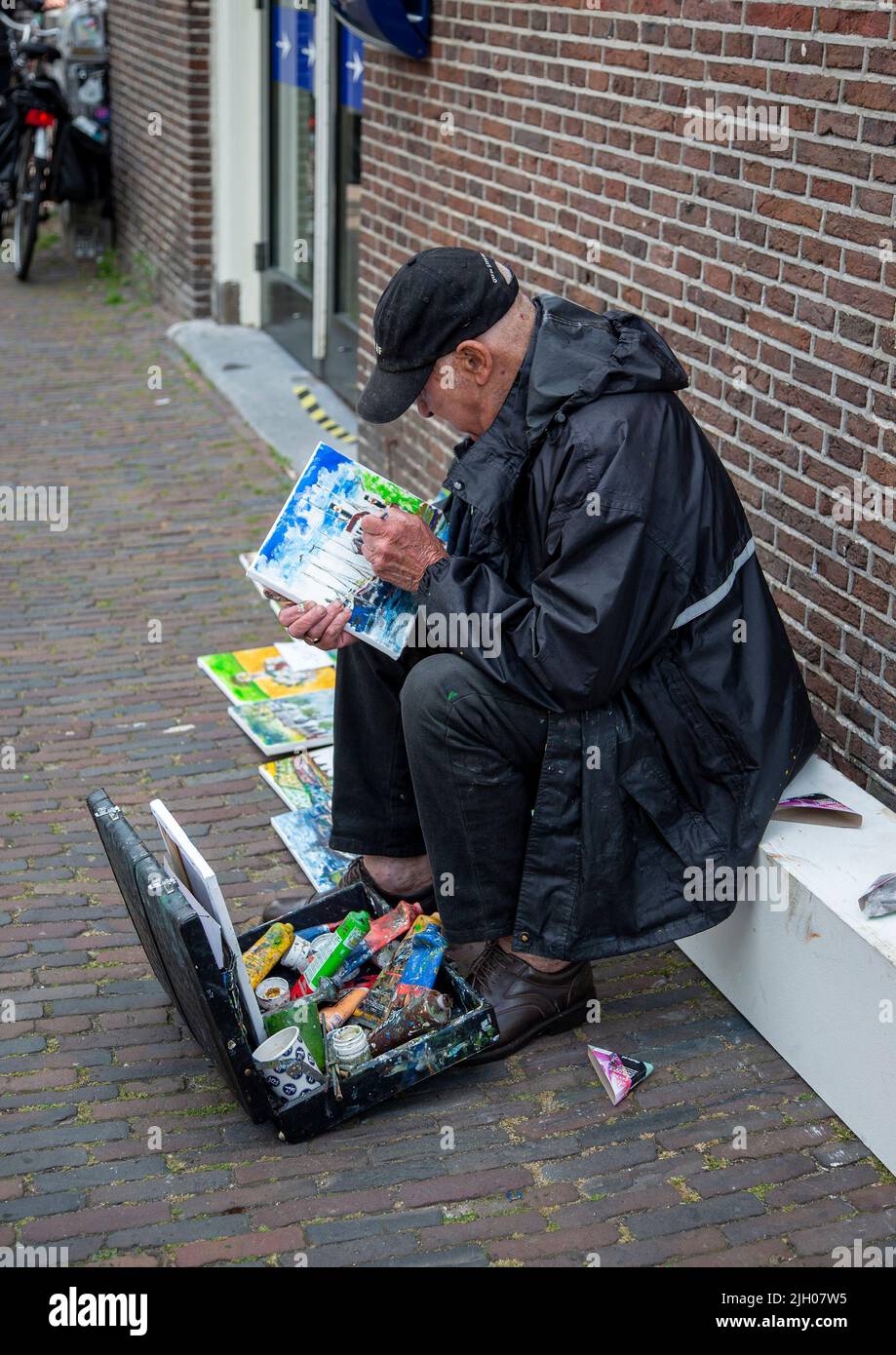 Artista che lavora a un dipinto vicino a un canale di Amsterdam Foto Stock