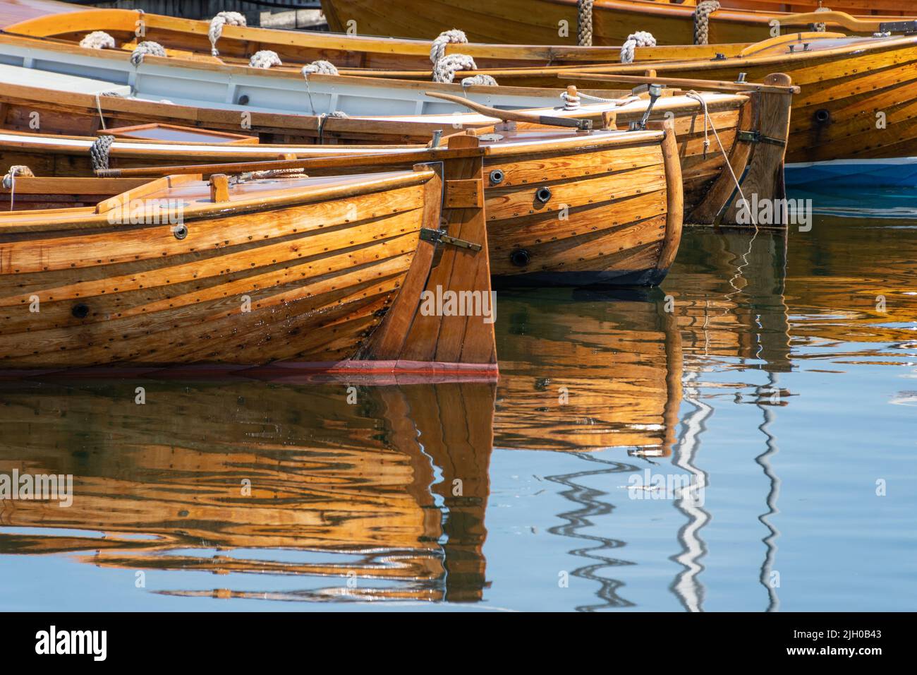 Tradizionali barche a remi in legno allineate nel porto. Foto Stock