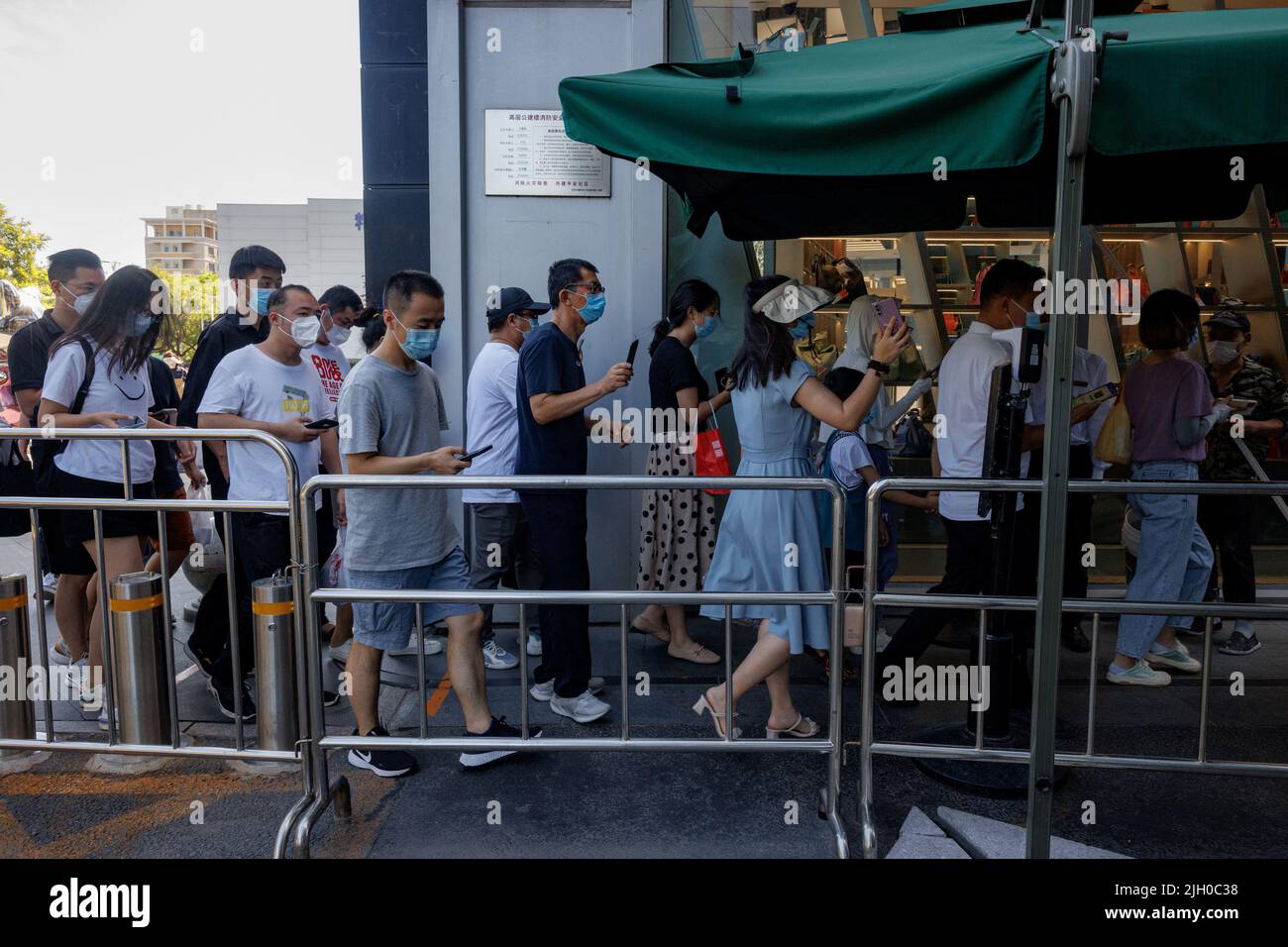 Le persone mostrano il proprio codice sanitario app quando entrano in un'area commerciale prima dell'orario d'ufficio, a seguito di un focolaio di coronavirus (COVID-19), a Pechino, Cina, 14 luglio 2022. REUTERS/Thomas Peter Foto Stock