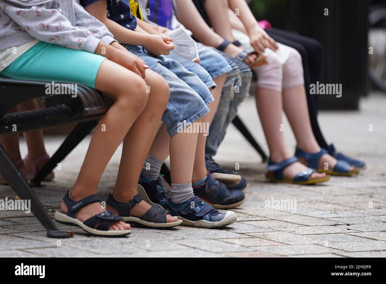 Amburgo, Germania. 13th luglio 2022. Bambini seduti su una panchina nei cortili della città. Credit: Marcus Brandt/dpa/Alamy Live News Foto Stock