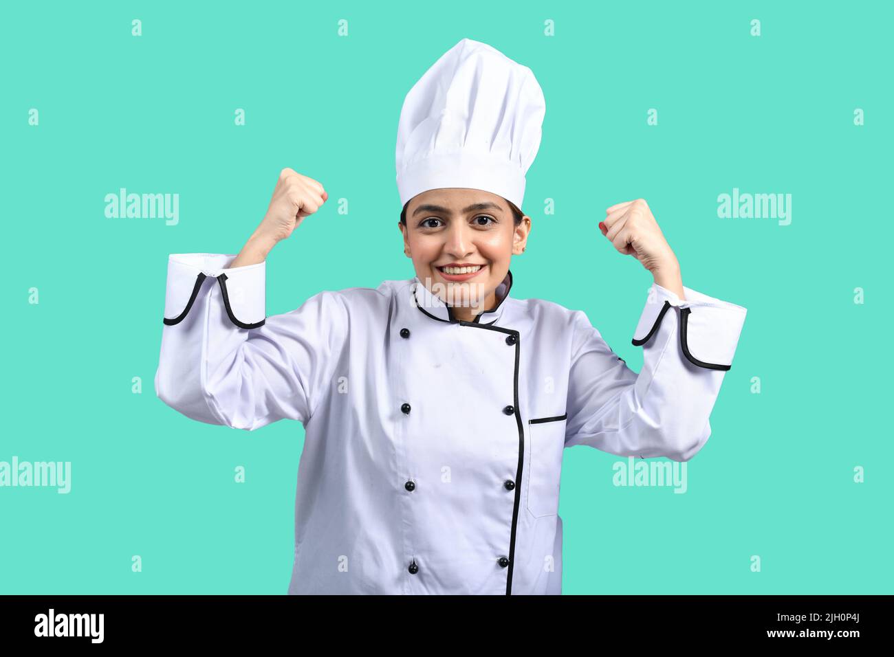 Chef femminile che mostra espressione felice con sorriso a causa del suo successo Foto Stock