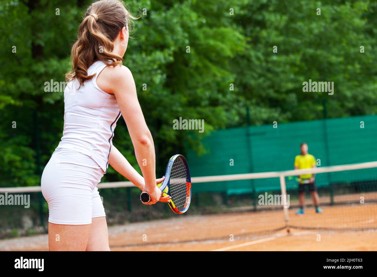 Giovane bella femmina giocatore di tennis di servire. Foto Stock