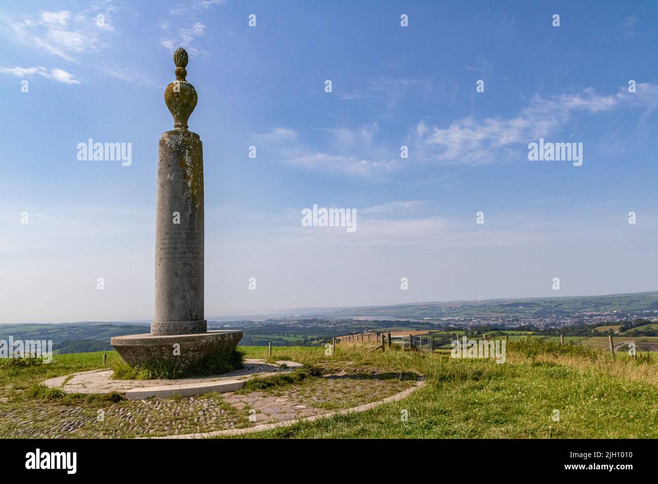 Particolare del Monumento di Caroline Thorpe sulla collina di Codden con una veduta distante di Barnstaple e dell'estuario del Taw. Foto Stock