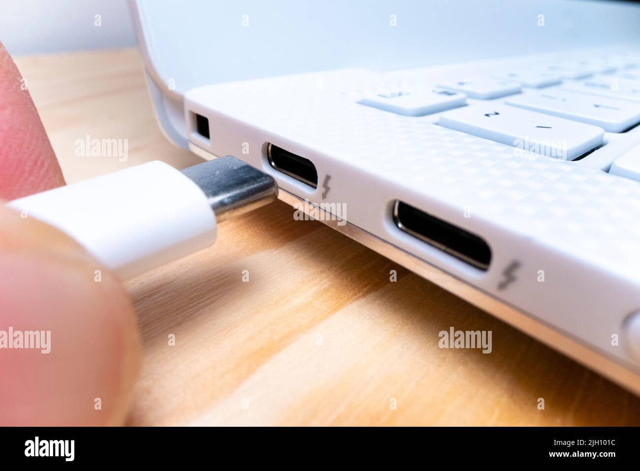 Vista macro ravvicinata del collegamento del cavo USB di tipo C alla porta del computer portatile, ripresa con l'obiettivo della sonda macro Foto Stock