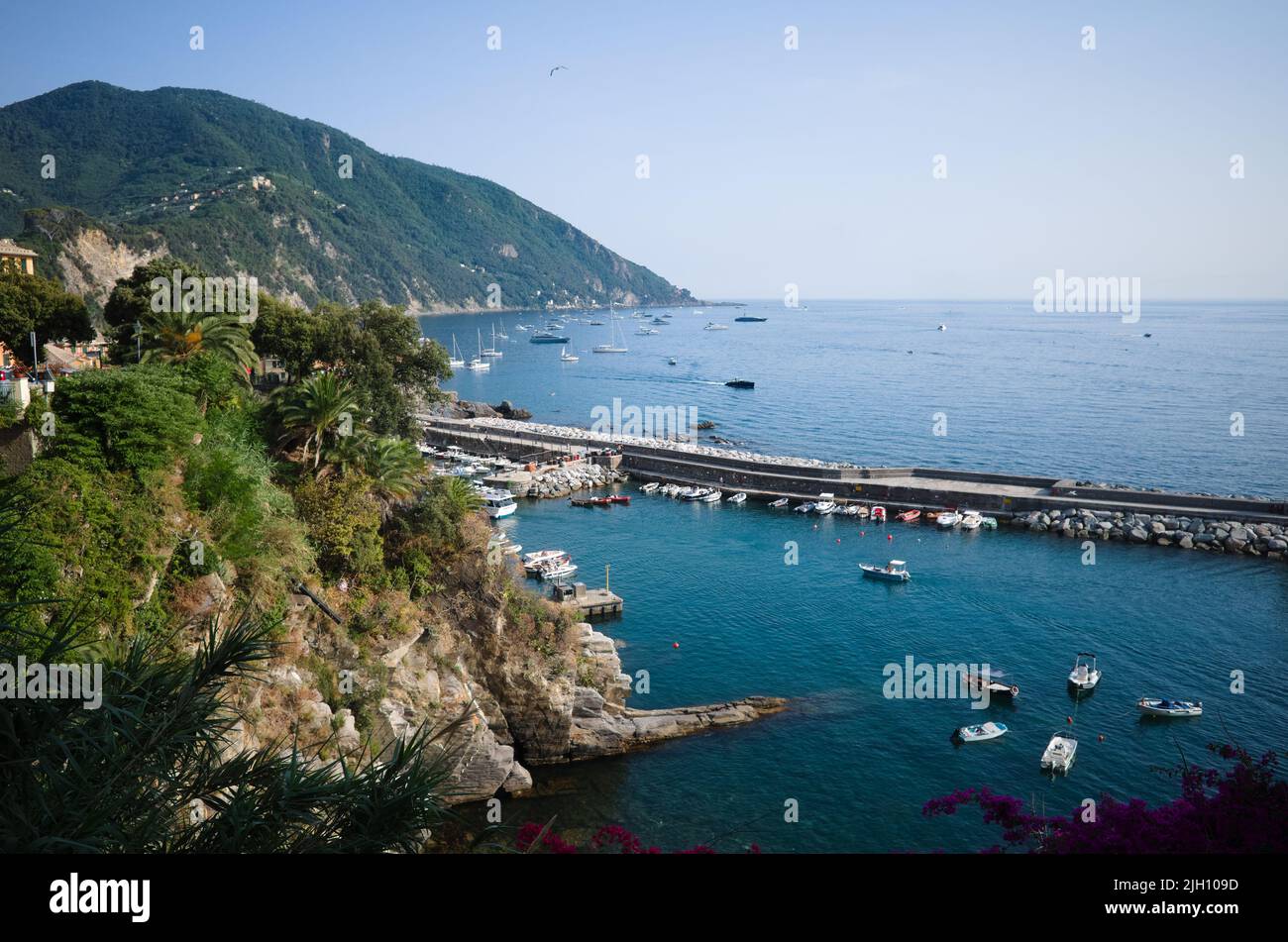 Mare con lunghissimo frangiflutti vicino al porto di Camogli, Liguria, Italia. Paesaggio mediterraneo della Riviera Italiana con costa rocciosa Foto Stock